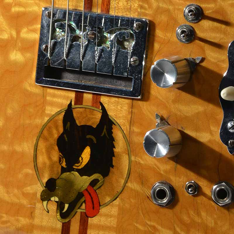 Zoom of Jerry Garcia's guitar with a cartoon wolf inlay.